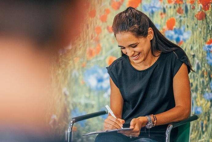 Therapeutin, die sich Notizen auf ihrem Klemmbrett macht.