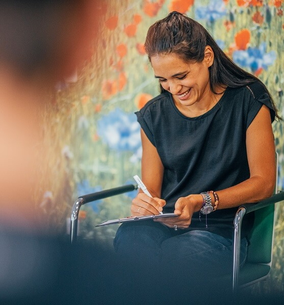 Therapeutin, die sich Notizen auf ihrem Klemmbrett macht.