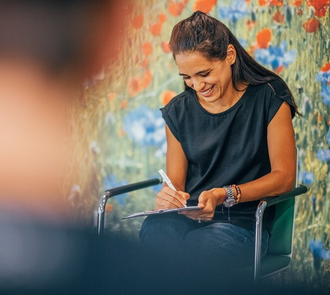 Therapeutin, die sich Notizen auf ihrem Klemmbrett macht.