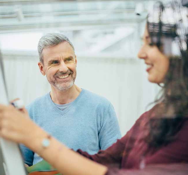 Ein Mann und eine Frau arbeiten lächeln gemeinsam an einem Flipchart