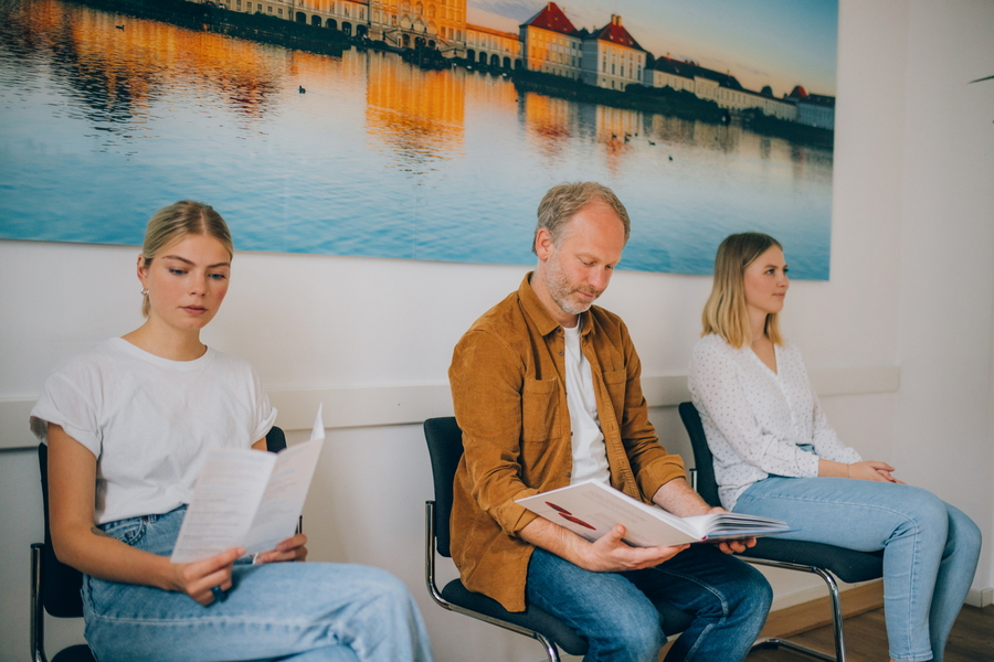 Drei Personen sitzen im Wartezimmer der KIRINUS Praxis Am Kurpark in Bad Tölz.