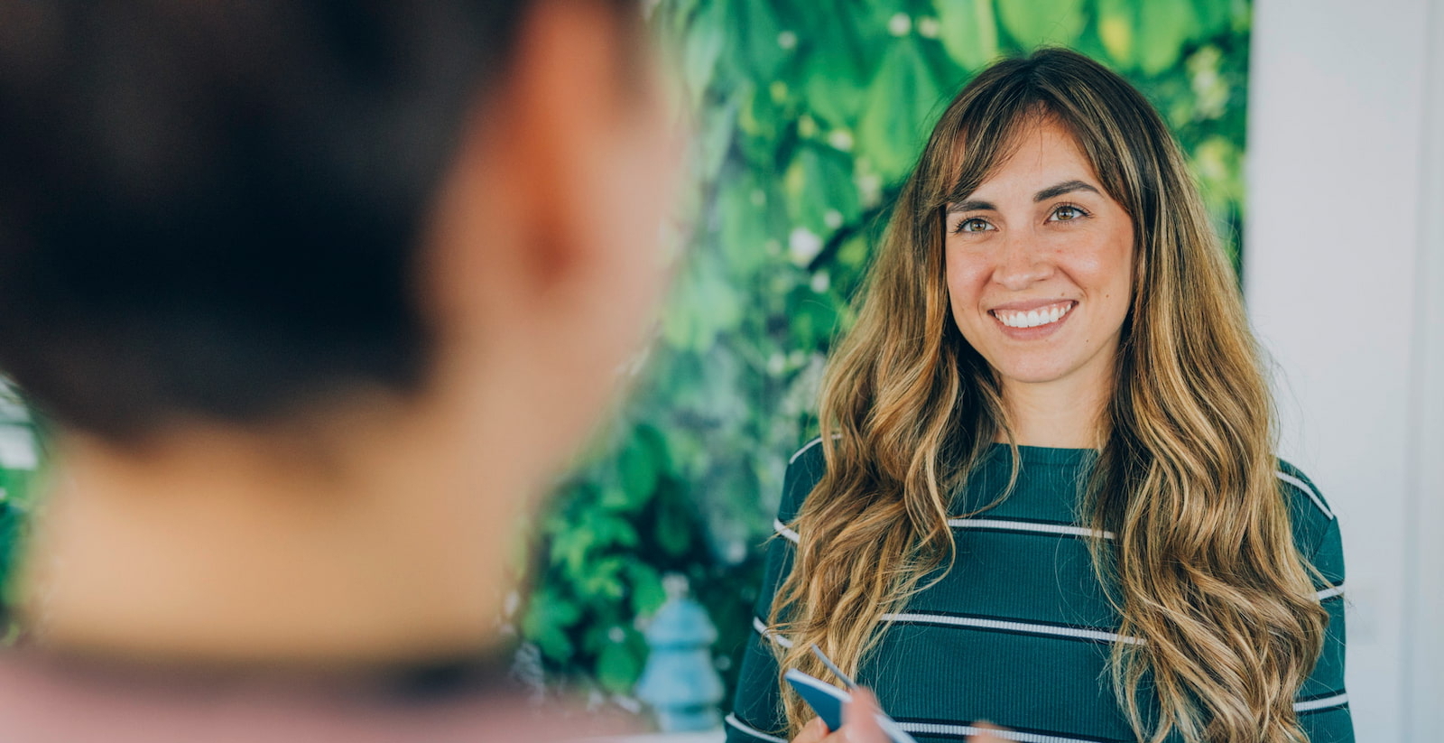 Freundlich lächelnde Frau begrüßt Patienten bei KIRINUS