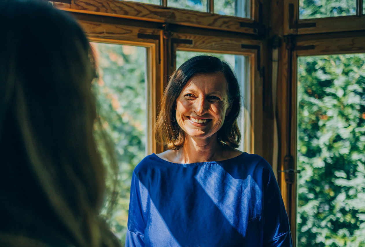 Gesprächssituation zwischen zwei Frauen am Fenster der KIRINUS Schlemmer Klinik