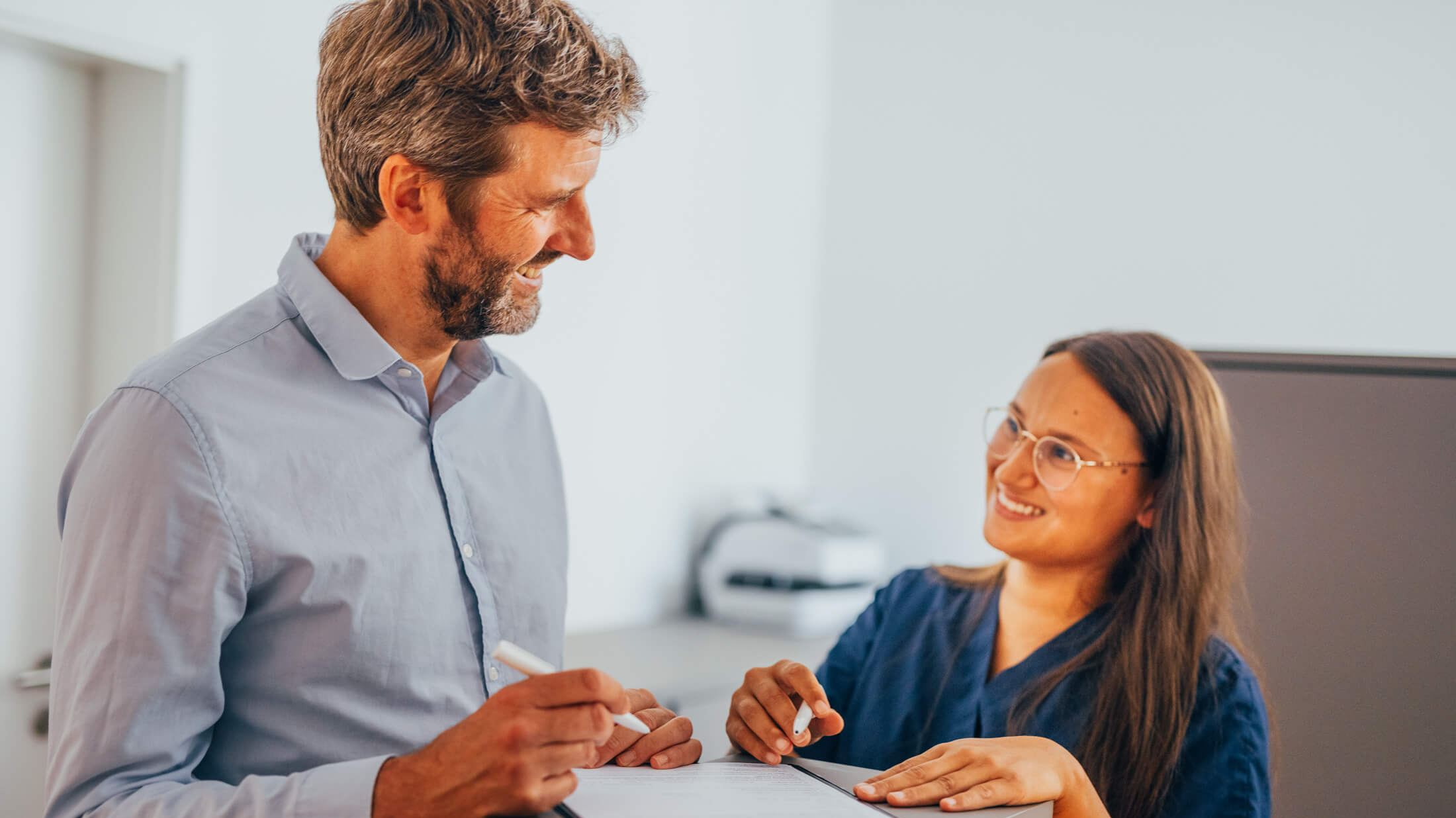 Gesprächssituation zwischen zwei Personen am Empfang bei KIRINUS