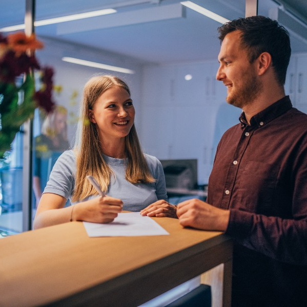 Gespräch zwischen Patient und Empfangsmitarbeiterin