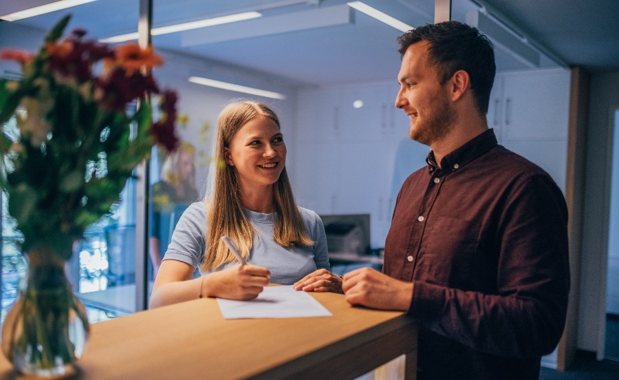 Gespräch zwischen Patient und Empfangsmitarbeiterin