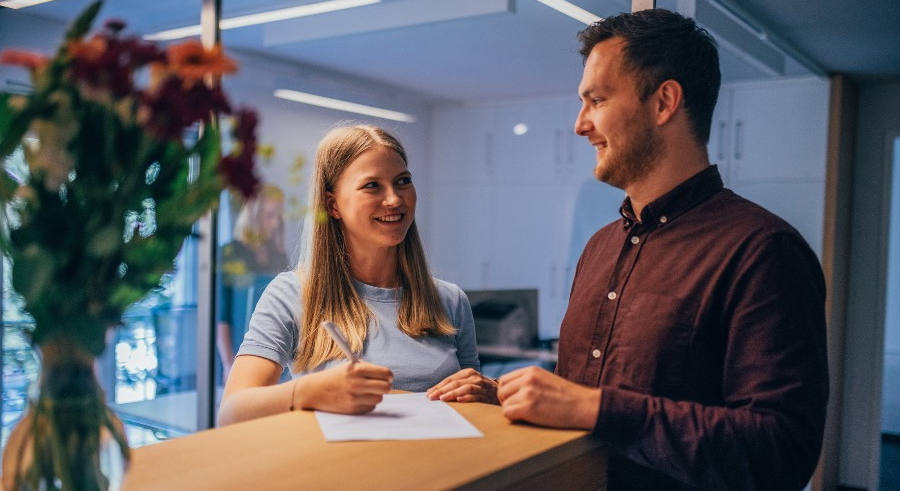 Gespräch zwischen Patient und Empfangsmitarbeiterin