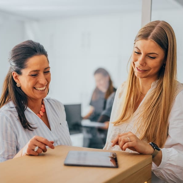 Zwei lächelnde Frauen während der Anmeldung in der Tagesklinik.