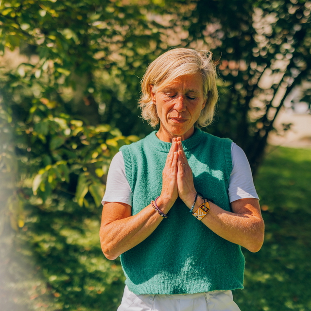 Frau bei einer achtsamen Körperübung im Freien.