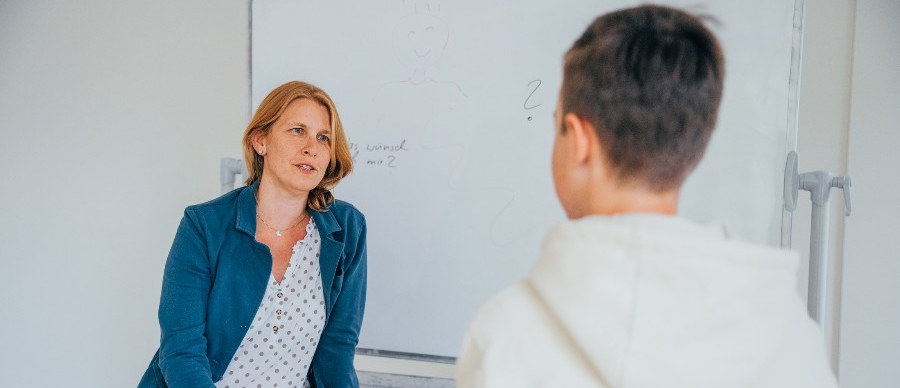 Eine Psychotherapeutin und ein junger Patient während der Enuresis-Therapie