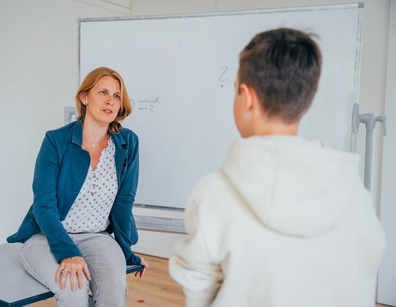 Gesprächssituation zwischen Therapeutin und jugendlichem Patienten.