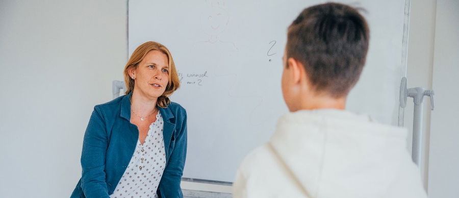 Eine Psychotherapeutin und ein junger Patient während der Enuresis-Therapie