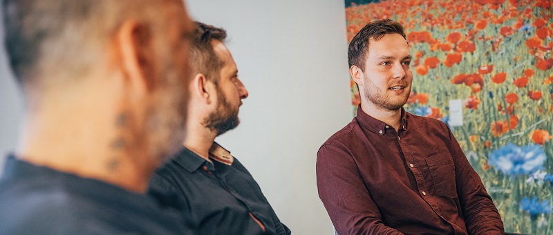 Drei Männer in einer Gesprächsgruppe zur Internetsucht-Behandlung