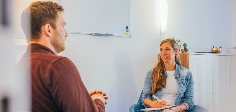 Eine Psychotherapeutin von KIRINUS und ein Patient mit Manie in der Therapie