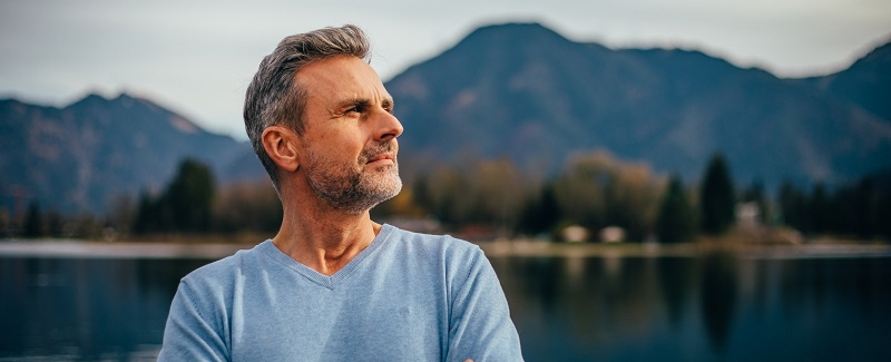 Ein Patient steht vor einer Bergkulisse und behandelt seine Schlafstörungen