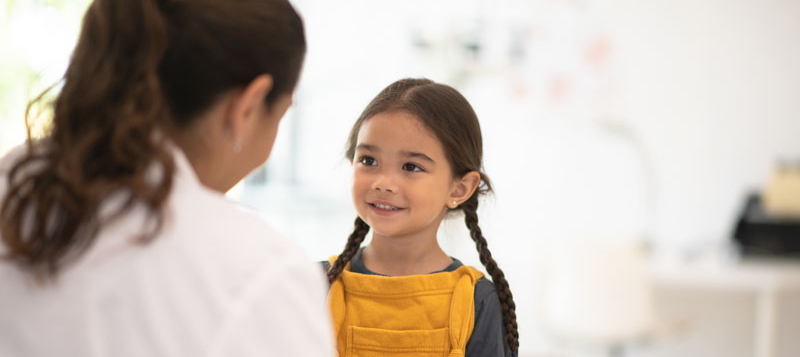 Ein junges Mädchen und eine Ärztin bei der Autismus-Behandlung