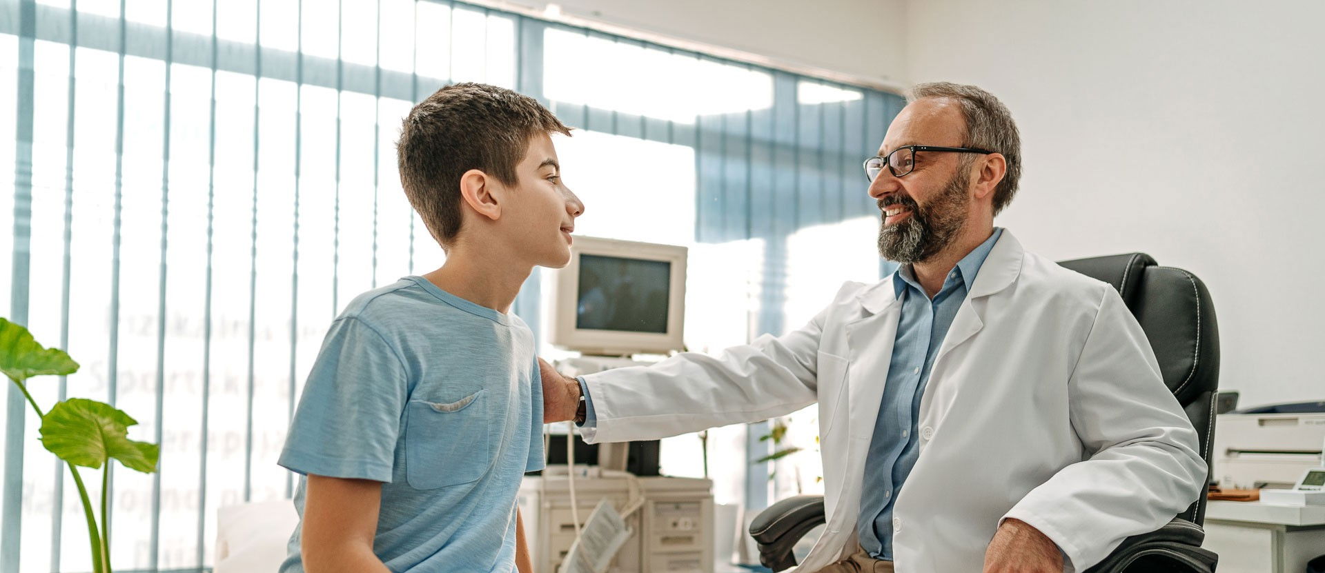 Kinderarzt legt seinem Patienten eine unterstützende Hand auf die Schulter