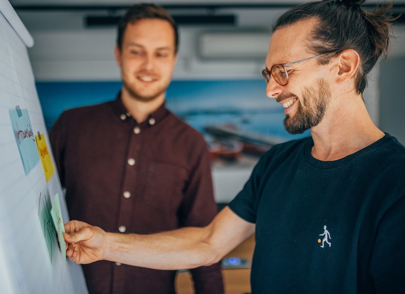 Zwei Psychotherapeuten in Ausbildung vor einem Flip-Chart