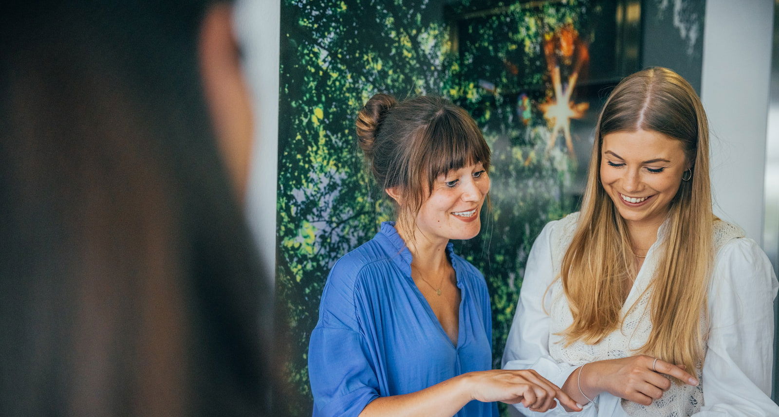 Zwei lächelnde Personen gucken gemeinsam auf ein Tablet