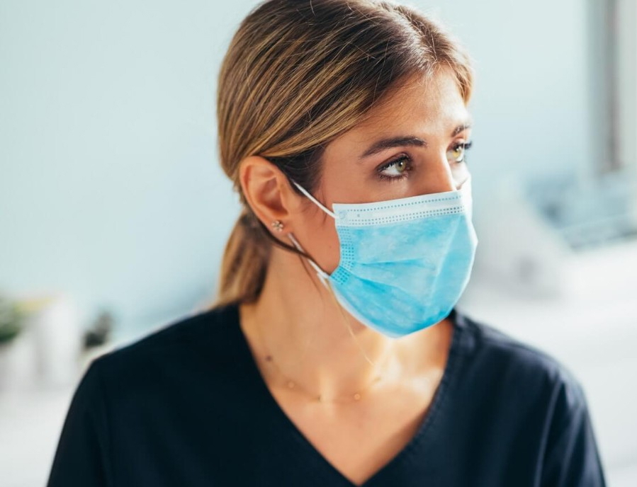 Medizinische Fachangestellte mit Maske bei der Arbeit