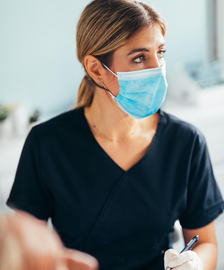 Medizinische Fachangestellte mit Maske bei der Arbeit