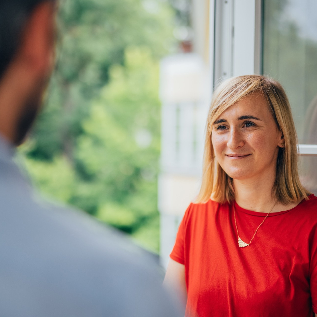 Gesprächssituation am Fenster mit Blick in die Natur