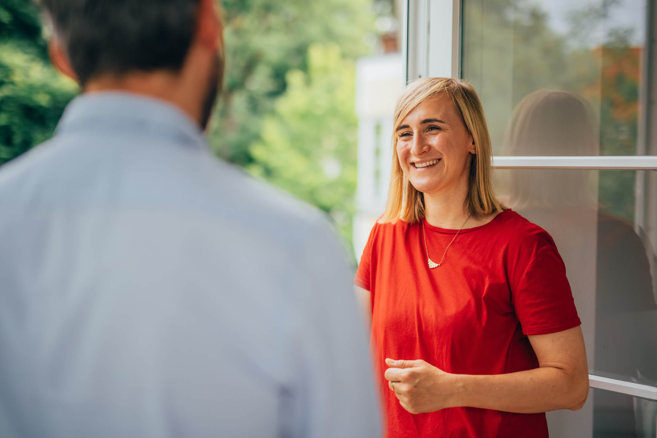 Gespräch zwischen zwei Personen am Fenster