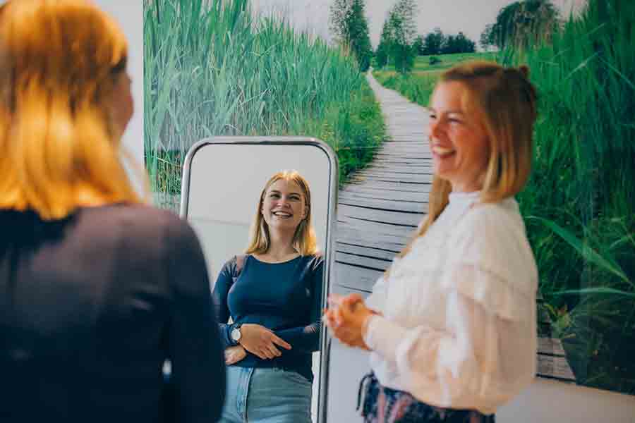 Jugendliche Patientin betrachtet sich während der Psychotherapie im Spiegel