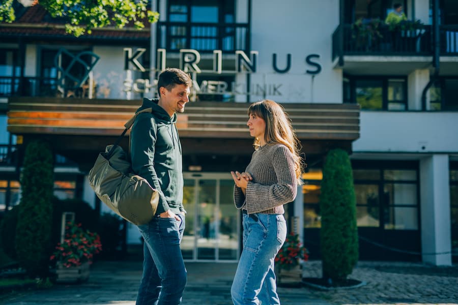 Zwei Personen vor dem Eingangsbereich der KIRINUS Schlemmer Klinik in Bad Tölz