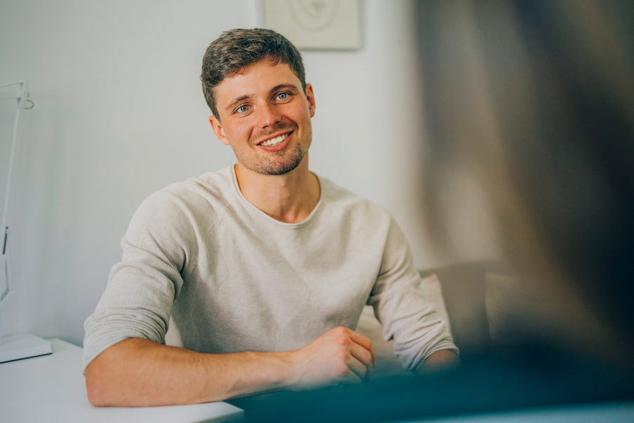 Patient lächelt während des Gesprächs mit seiner Psychotherapeutin.