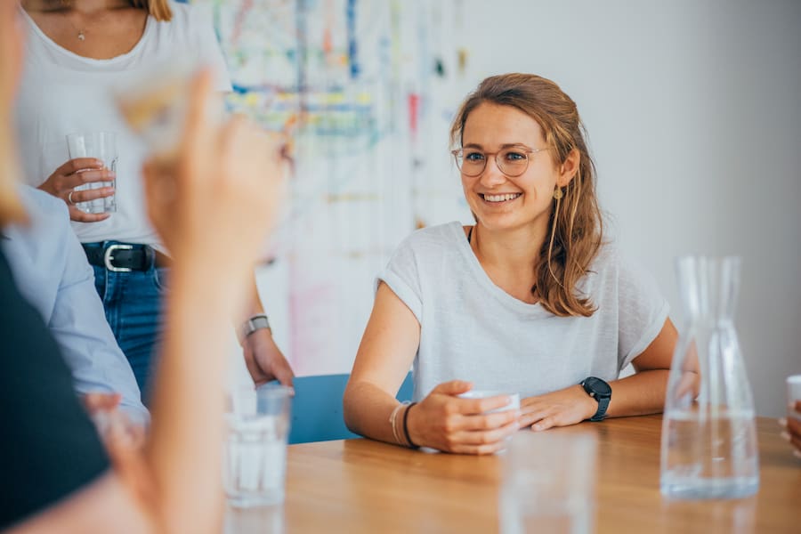 Mehrere Personen sitzen während ihres Aufenthalts in der Tagesklinik an einem Tisch und unterhalten sich.