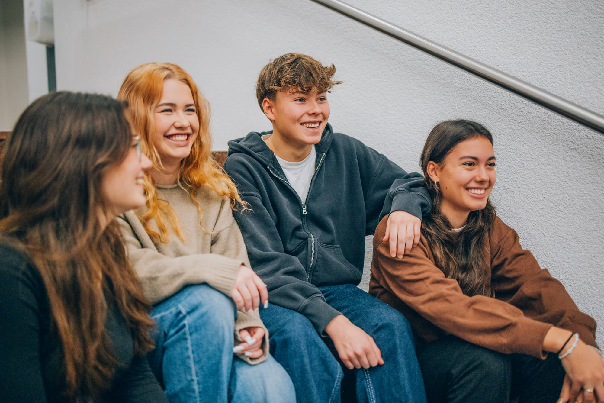Kinder und Jugendliche sitzen auf der Treppe bei KIRINUS