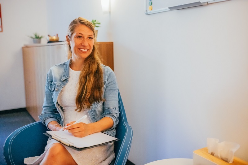 Psychotherapeutin während der Arbeit mit Klemmbrett in der Hand.