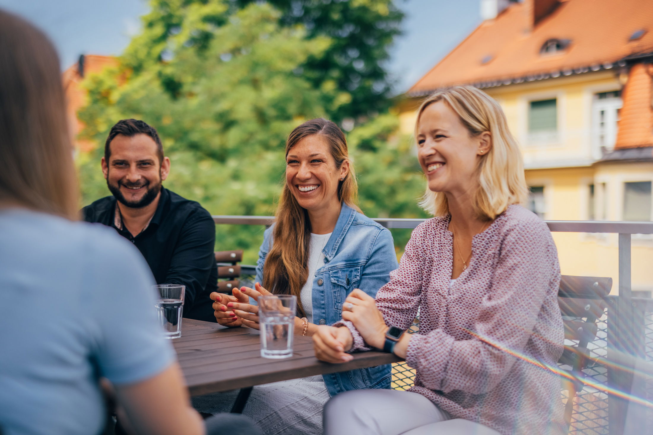 Gruppengespräch auf der Terrasse bei Sonnenschein