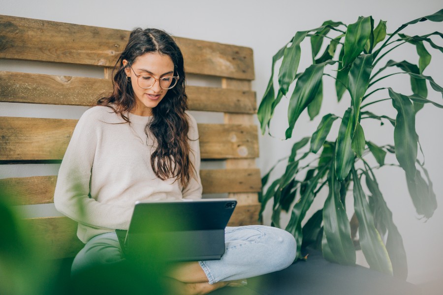 Eine Frau sitzt bequem an ihrem Laptop
