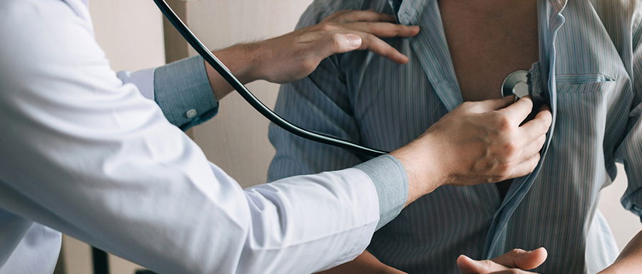 Arzt untersucht eine Patientin mit dem Stethoskop im Rahmen des Check-Up 35