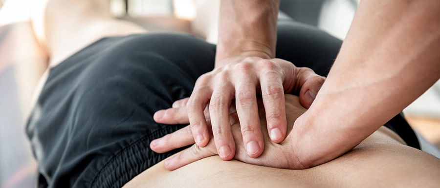 Physiotherapeut behandelt Patient während der Reha nach einer Spinalkanal-OP